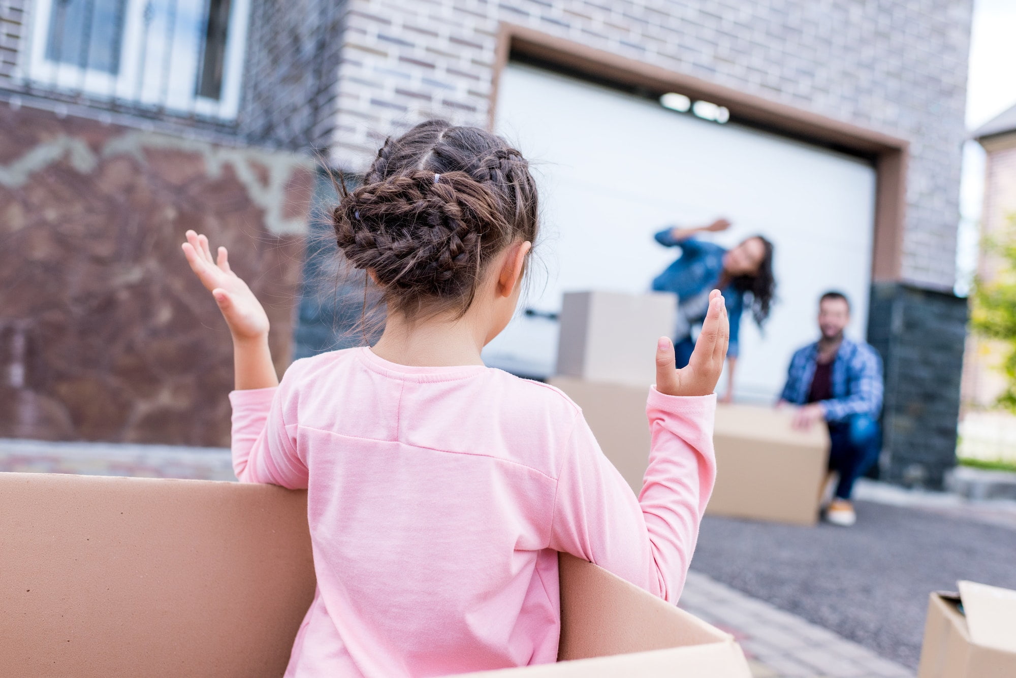 little girl playing with parents while moving into new home